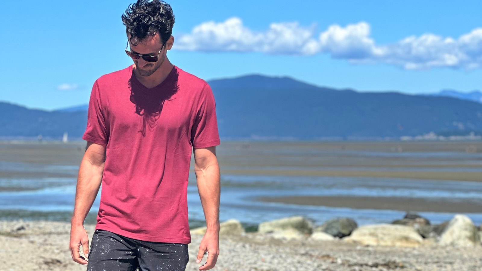 Tall guy walking on beach in red navas lab shirt